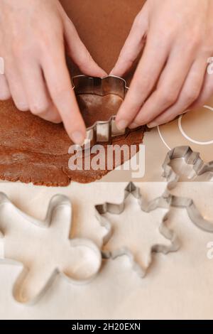 Lebkuchenteig für Weihnachtsplätzchen mit Metallformen geschnitten. Stockfoto