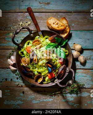 Tagliatelle mit Muscheln, Tomaten und Basilikum Stockfoto