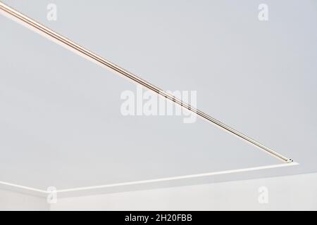 Abgehängte Decke mit quadratischer LED-Streifenlampe in leerem Raum in der Wohnung oder im Haus. Weiße Stretch-Decke mit matter körniger Textur. Renovierung des Hauses Stockfoto