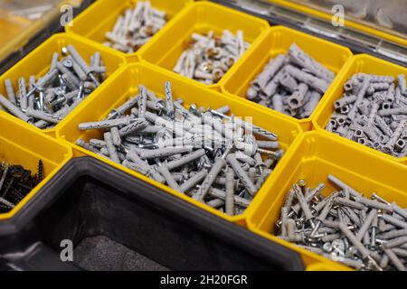 Viele Aufbewahrungsfächer gefüllt mit Bauherren Zubehör mit Schrauben, Muttern, Schrauben, Nägel und andere Werkzeuge in der Werkstatt. Gelbes Gehäuse mit kleinem c Stockfoto