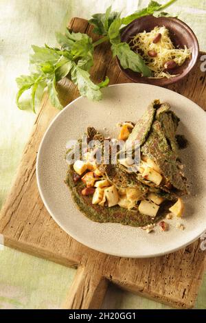 Kräuterpfannkuchen mit Pastinaken und Haselnüssen Stockfoto