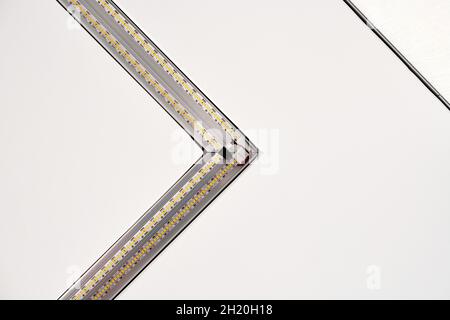 Strip LED-Lampe Beleuchtung mit quadratischem Aluminiumprofil an abgehängter Decke im Haus, Fragment, Nahaufnahme. Haus Renovierung Konzept und Umbau. Energie Stockfoto