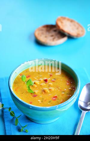 In einer rustikalen Schüssel mit gegrilltem Brot im Hintergrund eine urige Suppe Stockfoto