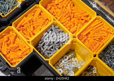 Viele Aufbewahrungsfächer gefüllt mit Bauherren Zubehör mit Schrauben, Muttern, Schrauben, Nägel und andere Werkzeuge in der Werkstatt. Gelbes Gehäuse mit kleinem c Stockfoto