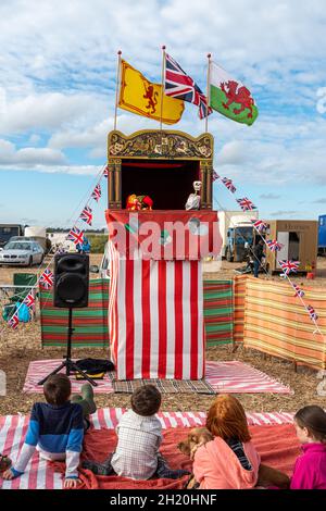 Kleine Kinder, Kinder, die eine traditionelle Puppentheater mit Punsch und Judy sehen, Großbritannien. Stockfoto