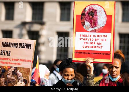 London, Großbritannien. Oktober 2021. Ein Protestler hält ein Schild mit der Aufschrift „Tigray wird von der äthiopischen Regierung verhungert“ während des Tigray-Genozidproteste in der Nähe der Downing Street 10 in London. Die Demonstranten protestierten gegen einen sogenannten „Völkermord-Krieg“ von Äthiopien und Eritrea in der Region Tigray und forderten das Vereinigte Königreich und die internationale Gemeinschaft auf, den Menschen in Tigray zu helfen. Kredit: SOPA Images Limited/Alamy Live Nachrichten Stockfoto