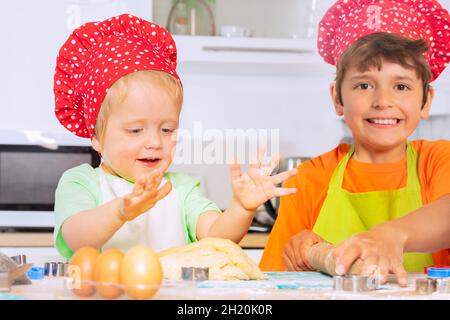 Glückliches Kleinkind mit Bruder bereiten Backteig Stockfoto