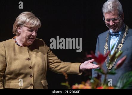 Greifswald, Deutschland. Oktober 2021. Bundeskanzlerin Angela Merkel (CDU) und Stefan Fassbinder (Bündnis 90/die Grünen), Oberbürgermeister, stehen auf der Bühne für den Stadtempfang der Hansestadt Greifswald. Beim Stadtempfang würdigt Greifswald ehrenamtliches Engagement und herausragende Leistungen. Quelle: Stefan Sauer/dpa/Alamy Live News Stockfoto