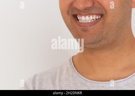 Nahaufnahme eines jungen Mannes mit brauner Haut und lächelndem Gummi. Konzept der weißen Zähne. Stockfoto