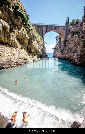 Fiordo di Furor ist eine gewölbte Steinbrücke, die diese eindrucksvolle Schlucht mit einem winzigen, felsigen Strand an seiner Basis überquert. Stockfoto
