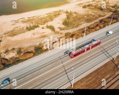 Die moderne Stadtbahn. Eine burgunderrote Straßenbahn auf den breiten Straßen von Kasan, Russland. Das Konzept des modernen Stadtverkehrs Stockfoto