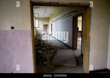 In der alten, braunliegenden und verlassenen sowjetischen Schule sind die Fenster und Türen und das Klassenzimmer gebrochen. Stockfoto