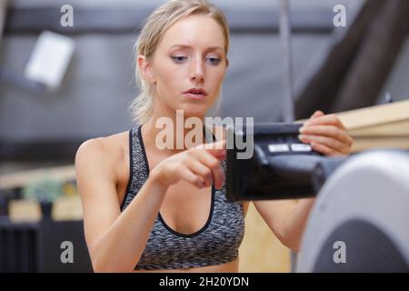 Sportlerin beim Training auf dem Rudergerät Stockfoto