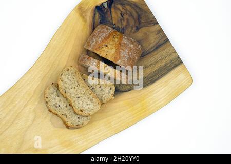 Roggenbrot in Scheiben geschnitten auf einem Holzbrett Draufsicht. Das Brot auf dem Schneidebrett isolieren. Hausgemachtes Sauerteigbrot mit Grieß bestreut. Stockfoto