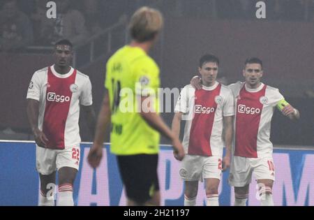 Amsterdam, Niederlande. Oktober 2021. Fußball: Champions League, Ajax Amsterdam - Borussia Dortmund, Gruppenphase, Gruppe C, Matchday 3, Johann Cruyff Arena. L-R: Amsterdams Seebastien Haller, Amsterdams Lisandro Martínez und Amsterdams Dusan Tadic jubeln nach der 1:0 ein eigenes Tor von Reus an. Quelle: Bernd Thissen/dpa/Alamy Live News Stockfoto