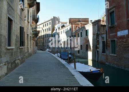 Blick auf einen schmalen Kanal, der von alten Backsteinhäusern in Venedig umgeben ist. Stockfoto