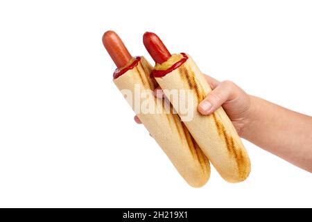 Weibliche Hand hält zwei französische Hot Dogs mit Ketchup und Senf auf weißem Hintergrund Stockfoto