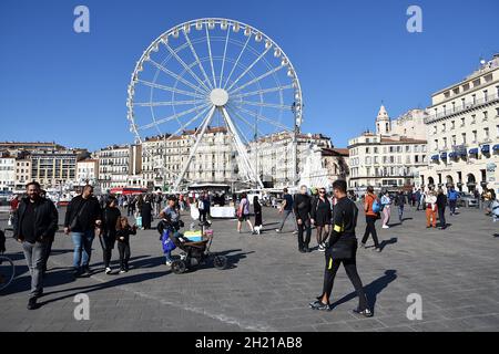 Marseille, Frankreich. Oktober 2021. Menschen beobachten das Riesenrad am Vieux-Port von Marseille.das Riesenrad wird am Vieux-Port von Marseille installiert, wo es für die Feierlichkeiten zum Jahresende stehen bleibt. (Foto von Gerard Bottino/SOPA Images/Sipa USA) Quelle: SIPA USA/Alamy Live News Stockfoto