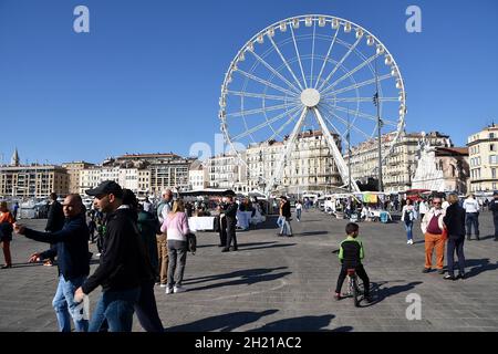 Marseille, Frankreich. Oktober 2021. Menschen beobachten das Riesenrad am Vieux-Port von Marseille.das Riesenrad wird am Vieux-Port von Marseille installiert, wo es für die Feierlichkeiten zum Jahresende stehen bleibt. (Foto von Gerard Bottino/SOPA Images/Sipa USA) Quelle: SIPA USA/Alamy Live News Stockfoto