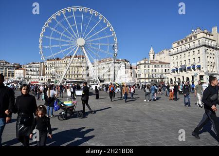 Marseille, Frankreich. Oktober 2021. Menschen beobachten das Riesenrad am Vieux-Port von Marseille.das Riesenrad wird am Vieux-Port von Marseille installiert, wo es für die Feierlichkeiten zum Jahresende stehen bleibt. Kredit: SOPA Images Limited/Alamy Live Nachrichten Stockfoto