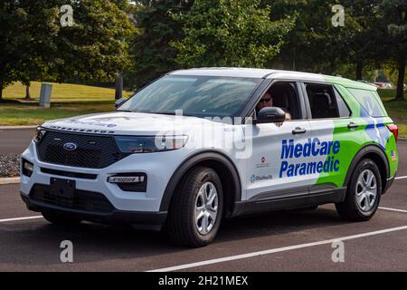 Columbus, OH USA 08-07-2021: Ein kaukasischer Ersthelfer wartet während einer Outdoor-Veranstaltung in einem Ford-Abfangwagen auf einem Parkplatz. Stockfoto