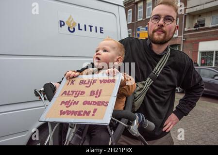 Rotterdam, Niederlande. Oktober 2021. Eltern mit einem Kind werden während des protestmarsches gegen die Wohnungskrise in Rotterdam mit einem Plakat gesehen.nach Angaben der Polizei nahmen heute mindestens 7,000 Demonstranten unter dem Motto "Häuser für Menschen, nicht für Profit" im Afrikaanderpark Teil und marschierten durch die Straßen von Rotterdam. Gegen 3 Uhr waren etwa zweitausend Demonstranten im Park, eine Zahl, die von NOS News geschätzt wird. Kredit: SOPA Images Limited/Alamy Live Nachrichten Stockfoto