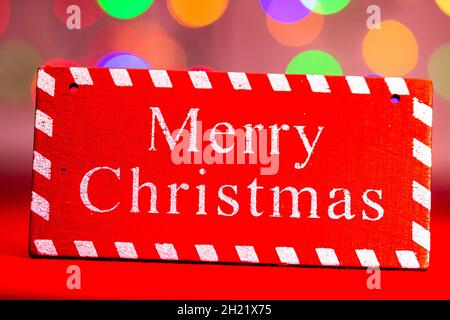 Rote fröhliche Christmas Holzschild mit einem bunten Bokeh Hintergrund Stockfoto