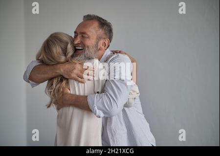 Glücklicher Mann umarmte seine Frau nach ihrer Wiedervereinigung Stockfoto