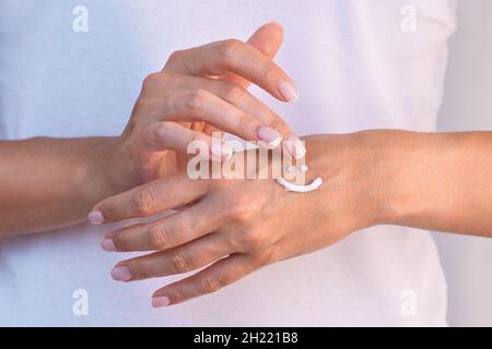 Frau, die Handcreme auftragen. Schutz der Haut der Hand. Frau, die Schutzcreme oder Feuchtigkeitscreme anwendet. Handpflege oder Hautpflege Konzept Stockfoto