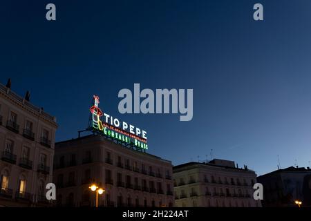 Das Wahrzeichen von Tío Pepe, eine Werbung für Tío Pepe Sherry, beleuchtet die Puerta del Sol bei Sonnenuntergang in Madrid, Spanien. Stockfoto