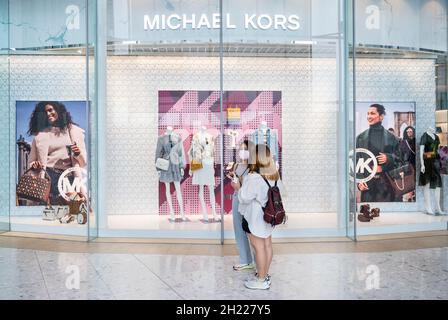 Hongkong, China. Oktober 2021. Käufer stehen vor dem Logo der amerikanischen Bekleidungsmarke Michael Kors (MK) und lagern im Bezirk Tung Chung in Hongkong. (Bild: © Budrul Chukrut/SOPA Images via ZUMA Press Wire) Stockfoto
