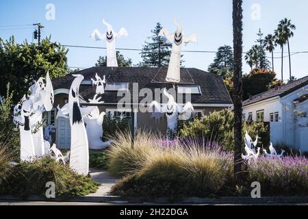 Kleines Spukhaus in Kalifornien mit mehr als einem Dutzend aufblasbarer Geister; auf dem Dach und im Garten unter den Pflanzen - ein gruseliger halloween Stockfoto