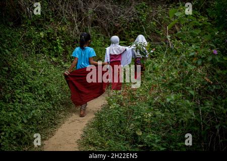 Maros, Indonesien. Oktober 2021. Diese drei Kinder, die zu Fuß gehen, sind einige der Kinder, die weit von ihrer Schule entfernt leben. Jeden Tag gehen diese Kinder Hügel hinunter und über Flüsse, um in der abgelegenen Schule SD 246 Bonto-Bonto, Maros, Süd-Sulawesi, Indonesien, in der Schule bleiben zu können. (Foto: Jumadil Awal/Pacific Press) Quelle: Pacific Press Media Production Corp./Alamy Live News Stockfoto