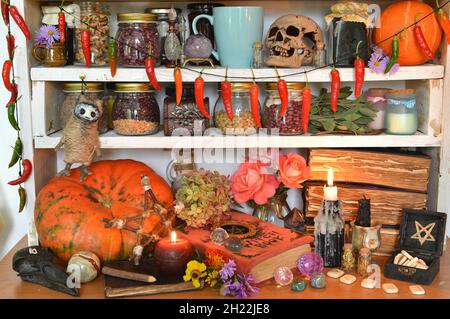 Vintage Küche Stillleben mit Hexerei Ritual obects, mystische Bücher von Zaubersprüchen, Flasche Trank, Schädel, Kürbis und brennende Kerze auf Holz zählen Stockfoto