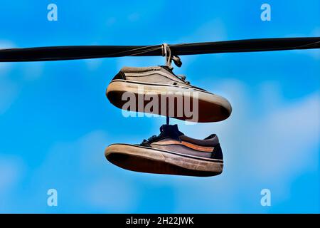 Ein Paar Laufschuhe, das in New Brunswick, Kanada, über ein Stromkabel geworfen wird. Stockfoto