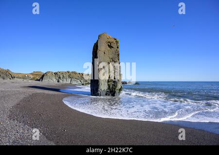 Wellen schlagen gegen einen felsigen Aufschluss an der Südküste, Djupivogur, Austurland, Island Stockfoto