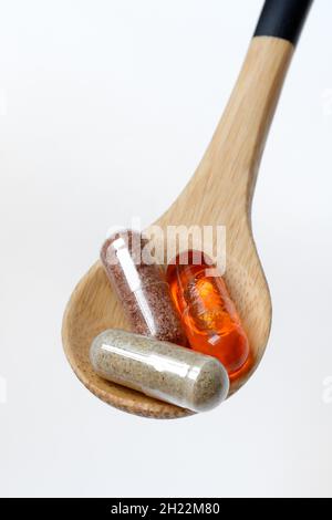 Kapseln mit Nahrungsergänzungsmittel und Omega-3-Fettsäure in Holzlöffel Stockfoto