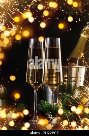 Zwei Sektgläser und goldene weihnachtsdekoration auf schwarzem Hintergrund. Happy New Year oder Merry Christmas Komposition Stockfoto