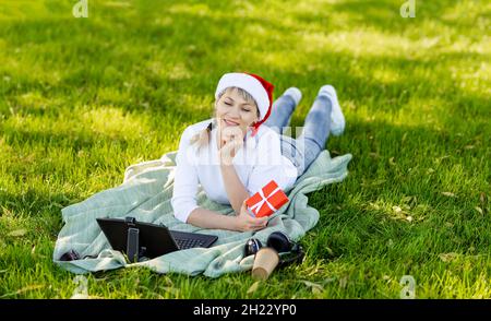 Weihnachten Online-Grüße. Porträt eines niedlichen Mädchen in Santa Hut Stockfoto