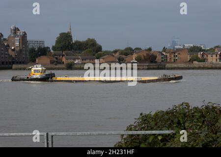 Schlepper SWS ESSEX schiebt bei Greenwich, London, Großbritannien, einen mit Schutt beladenen Seekahn auf die Themse Stockfoto