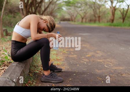 Frau in Sportbekleidung nach dem Laufen müde. bali Stockfoto