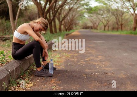 Frau müde, nachdem sie im Wald gelaufen ist. bali Stockfoto