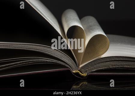 Nahaufnahme von Buchseiten, die in Form von gefaltet sind Ein Herz Stockfoto