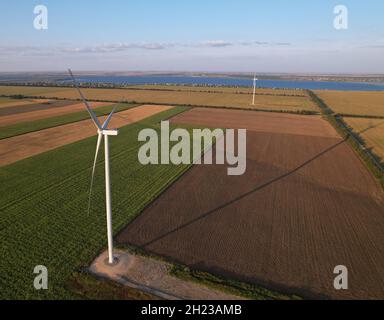 Windturbine auf Ackerland vor dem Hintergrund des Meeres. Stockfoto