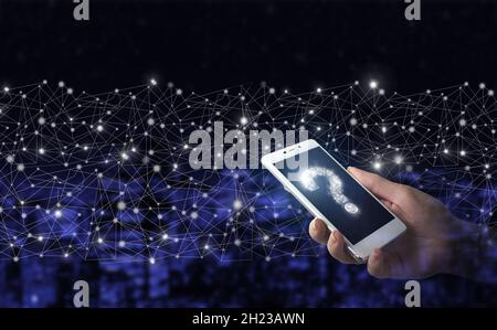 FAQ Häufig gestellte Fragen Konzept. Hand halten weißes Smartphone mit digitalen Hologramm Fragezeichen Zeichen auf Stadt dunkel verschwommen Hintergrund Stockfoto
