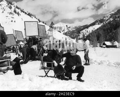 CLAUDETTE COLBERT am Set offen mit Movie Crew in Sun Valley Idaho während Drehorte für Ich TRAF IHN IN PARIS 1937 Regisseur WESLEY RUGGLES Kostümdesign Travis Banton Paramount Picters Stockfoto