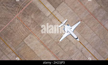 Geparkt teure Privatflugzeug auf Betonboden des Flughafens, Luft. Der kleine Geschäftsjet parkte auf dem entlaufendem Weg Stockfoto