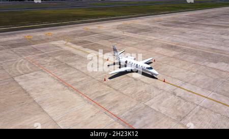 Geparkt teure Privatflugzeug auf Betonboden des Flughafens, Luft. Der kleine Geschäftsjet parkte auf dem entlaufendem Weg Stockfoto