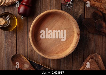 Runde leere Holzschüssel auf dem Holzhintergrund Stockfoto