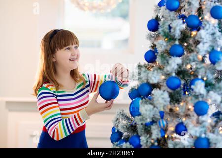 Kinder dekorieren Weihnachten zu Hause. Eröffnungsgeschenke und Geschenke am Weihnachtsmorgen. Blau und weiß Weihnachten Dekoration Thema. Stockfoto